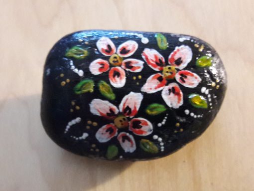 Zwarte steen met rose/witte bloemen